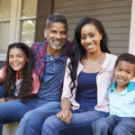 Family sitting outside their home.